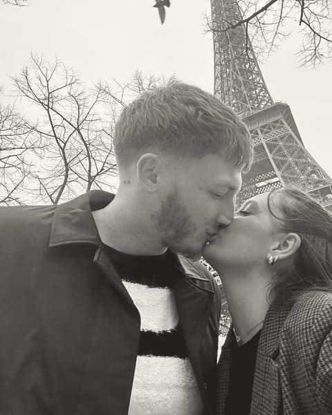 Tallulah and Thomas sharing a kiss in front of the Eiffel Tower
