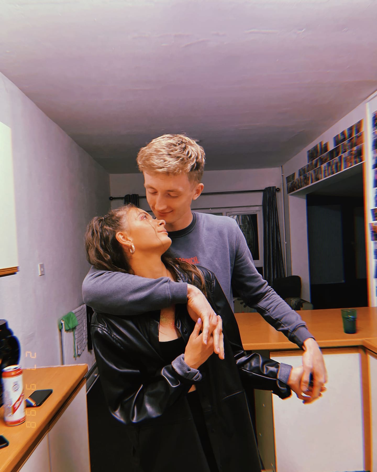 Tallulah and Thomas with their arms around each other in a kitchen