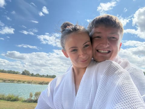 Tallulah and Thomas in white robes beside a lake