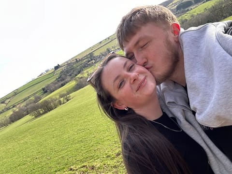 A kiss on the cheek on a sunny hillside