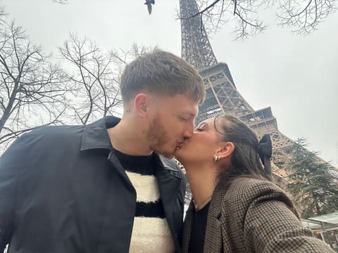 Tallulah and Thomas sharing a kiss in front of the Eiffel Tower