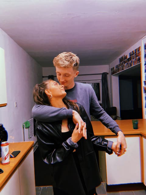 Tallulah and Thomas with their arms around each other in a kitchen